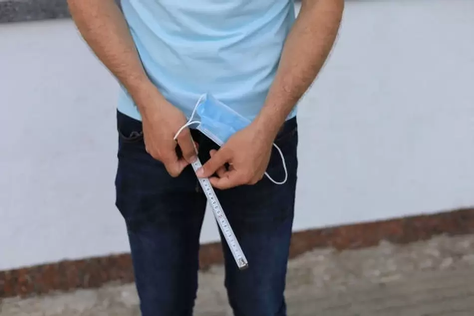 man measuring penis before enlarging